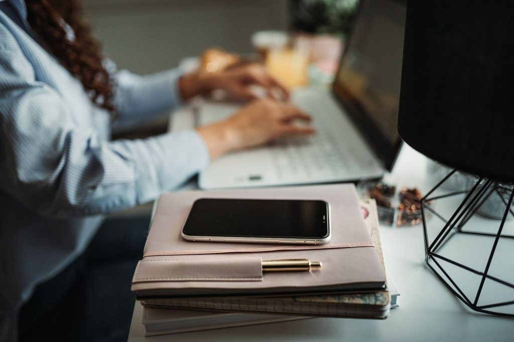 person working at desk with phone aside